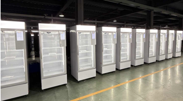 Una fila de máquinas expendedoras de refrigeradores inteligentes TCN AI en la línea de producción de la fábrica, sometidas a una inspección de calidad antes de su distribución global.